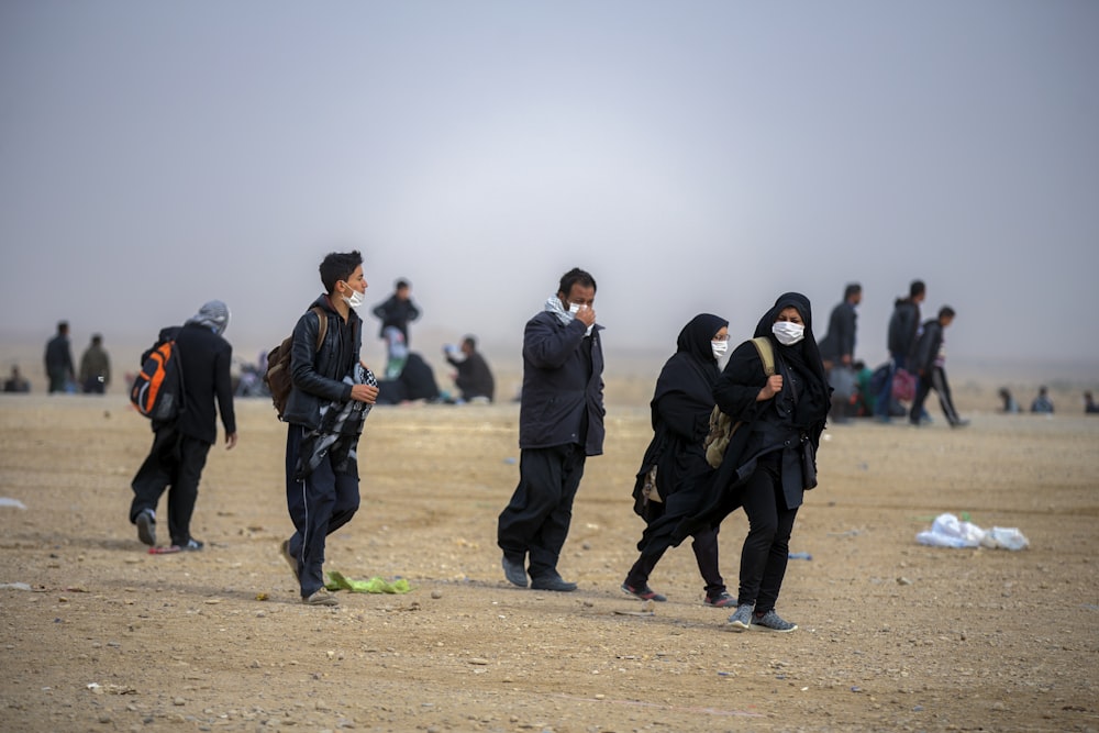 group of people walking on shore