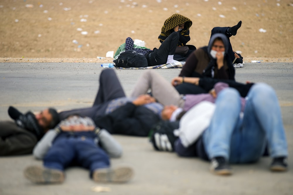 people lying on paved road