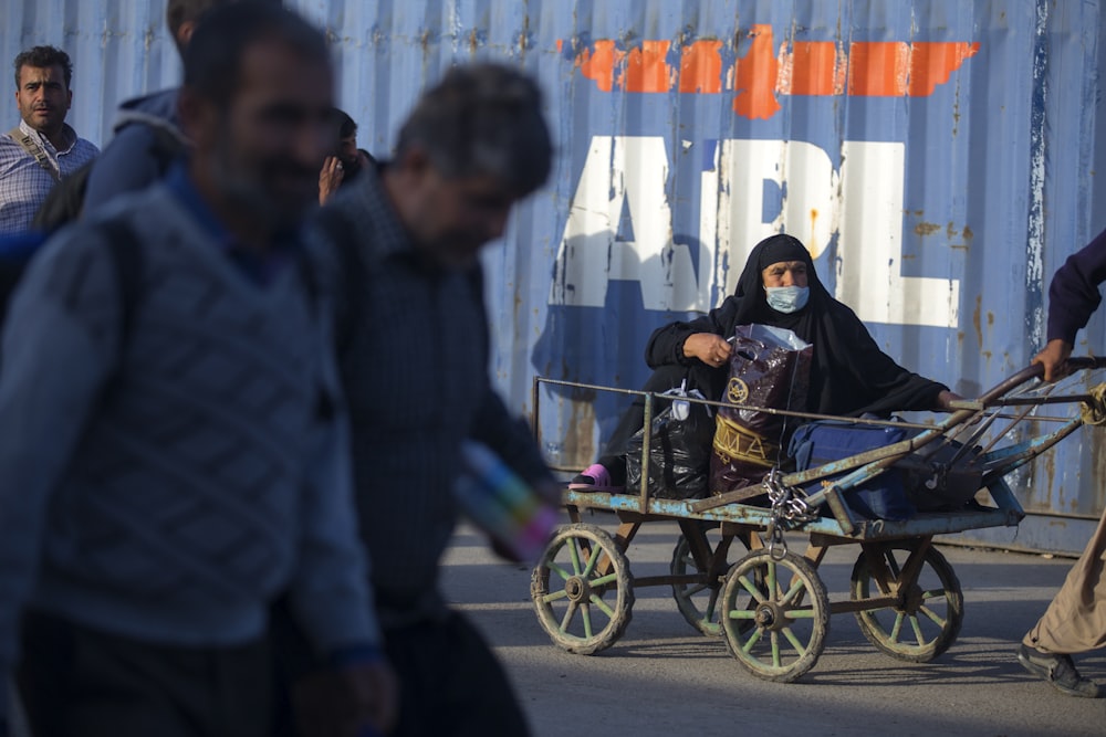 a woman in a face mask riding a horse drawn carriage