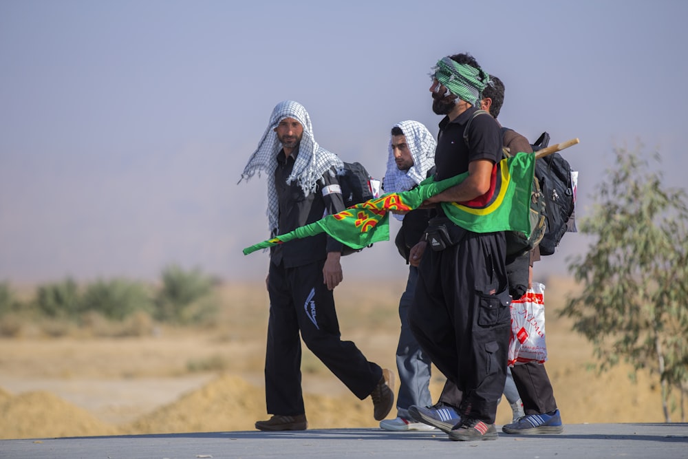 group of men walking with green flag