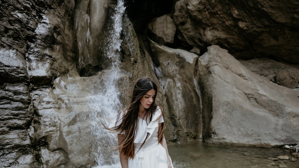 woman standing near waterfall