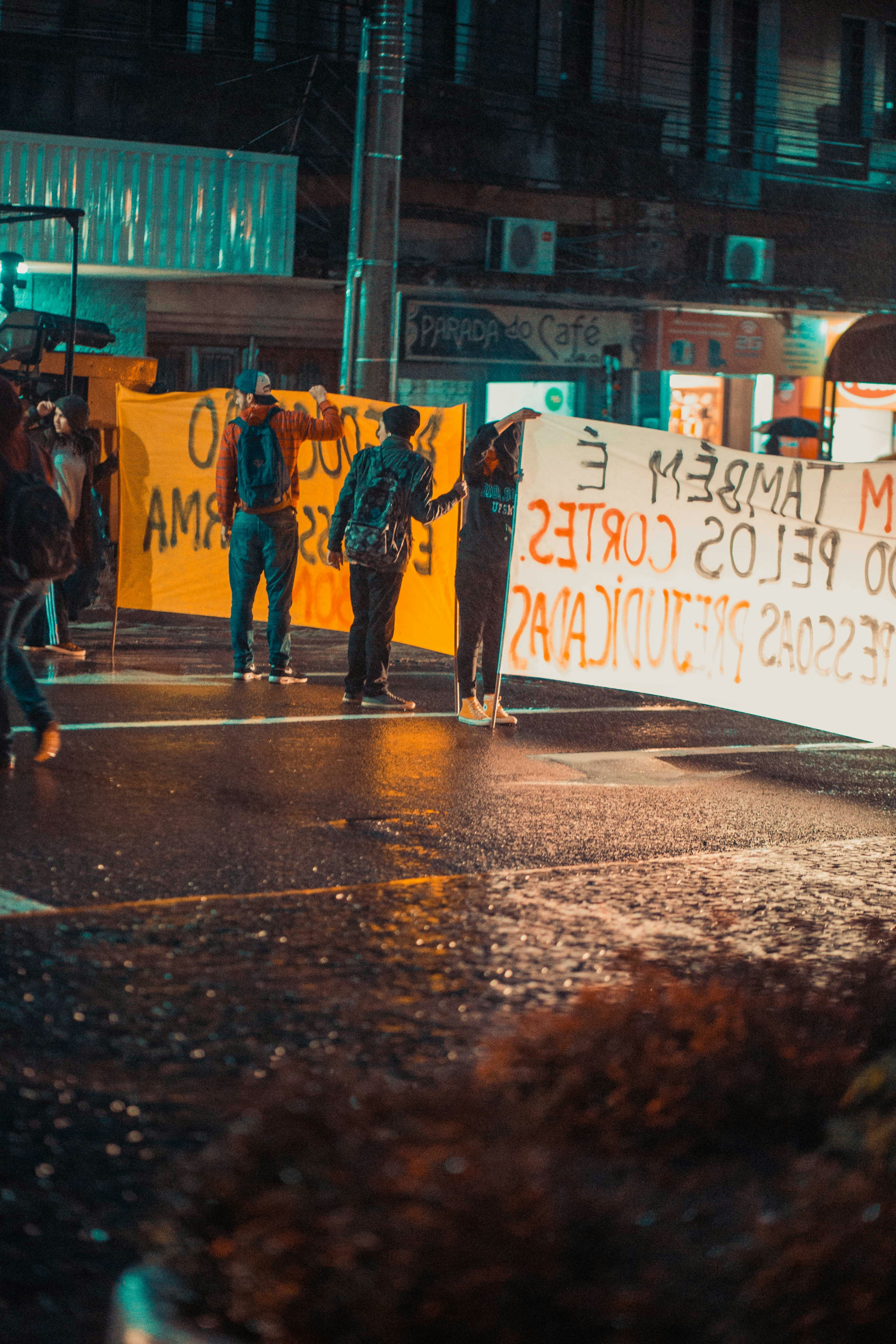 pessoas em pé na rua segurando a sinalização