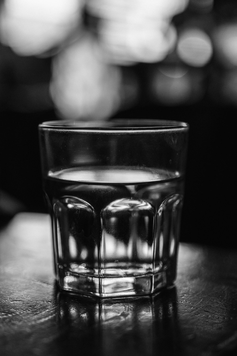 grayscale photo of a drinking glass with water