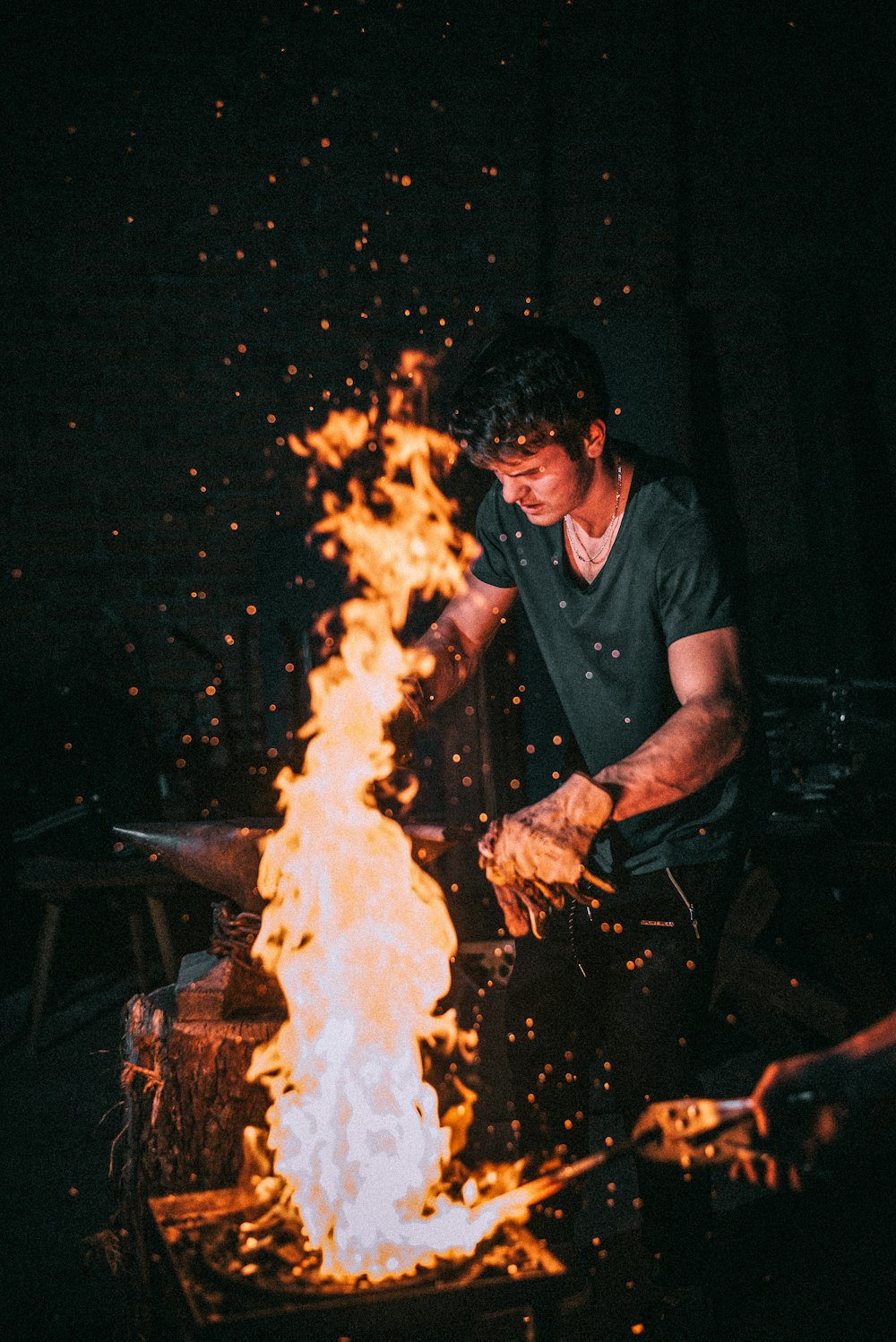 man standing beside flame during nighttime