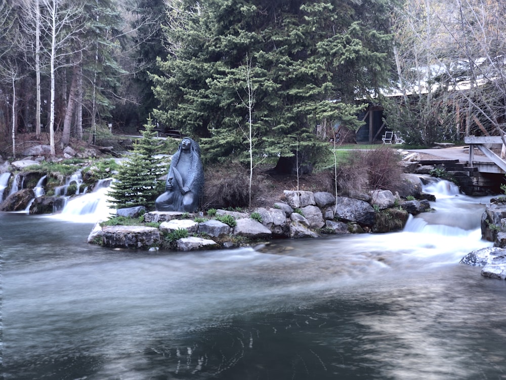 a small waterfall with a statue of a bear in the middle of it