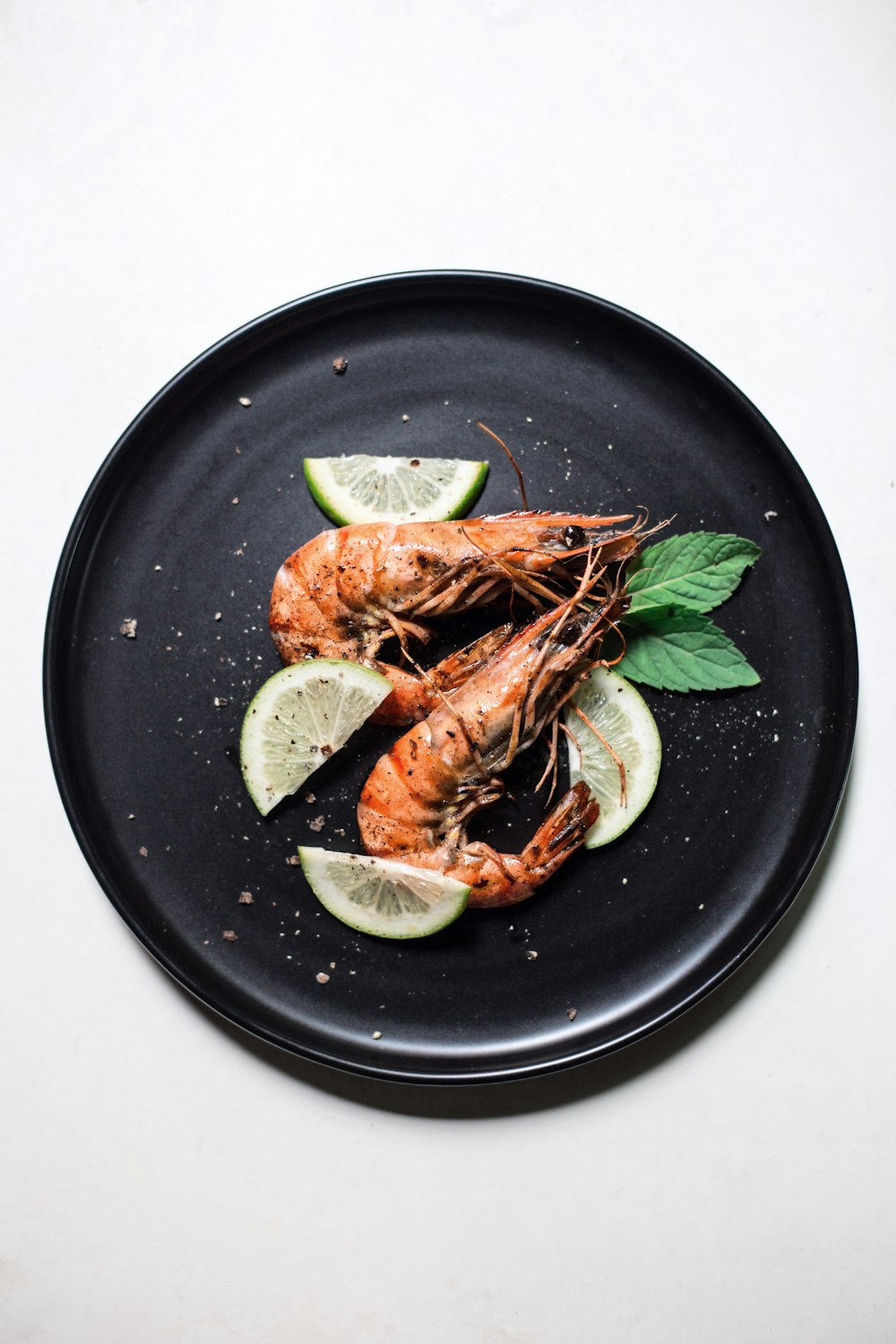 cooked shrimp with sliced of lime and basil
