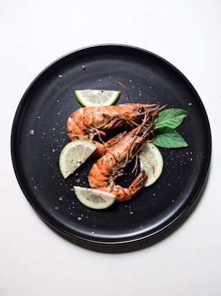 cooked shrimp with sliced of lime and basil