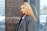 woman in gray suit jacket near glass wall