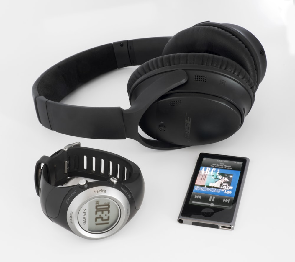 스마트워치 및 iPod 근처의 검은색 Bose 무선 헤드폰
