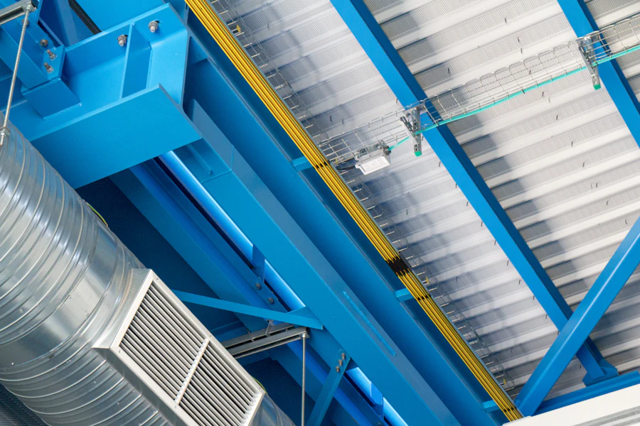 Spiral ductwork and an air handling unit below the steel ceiling of an industrial plant