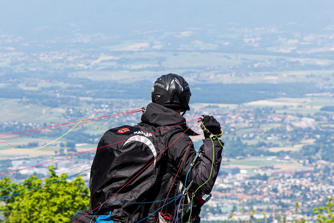 a man standing on top of a lush green hillside,