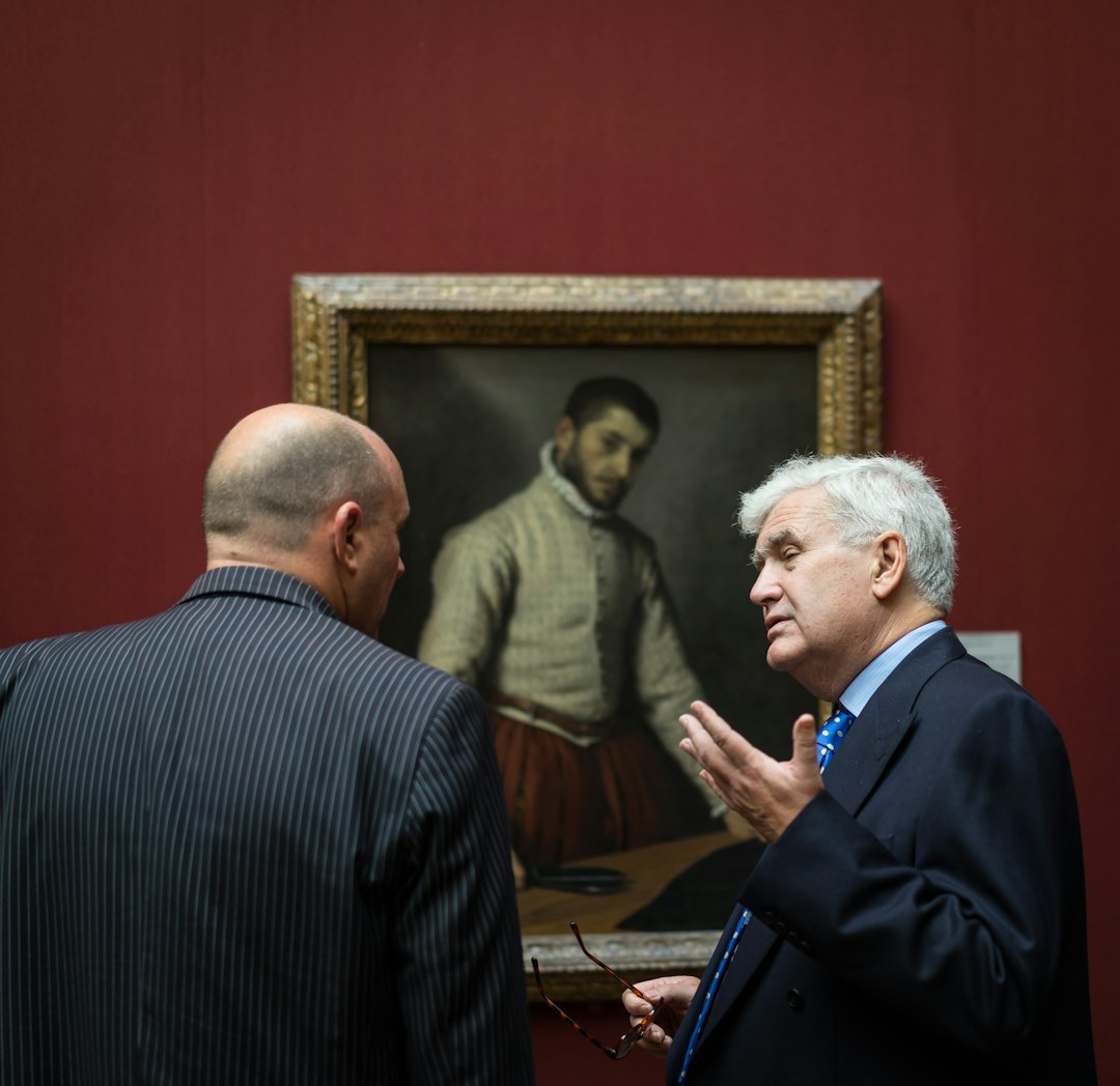 two men standing beside painting