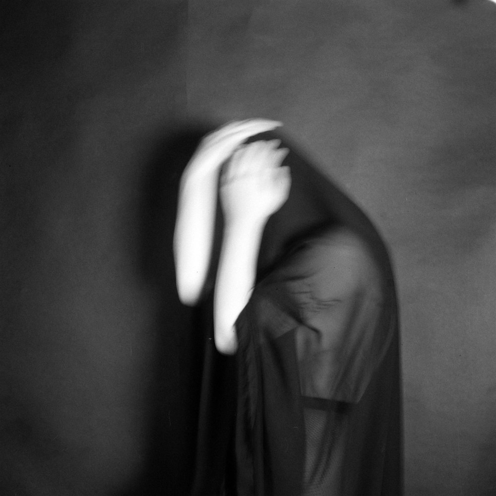 grayscale photography of person covering face