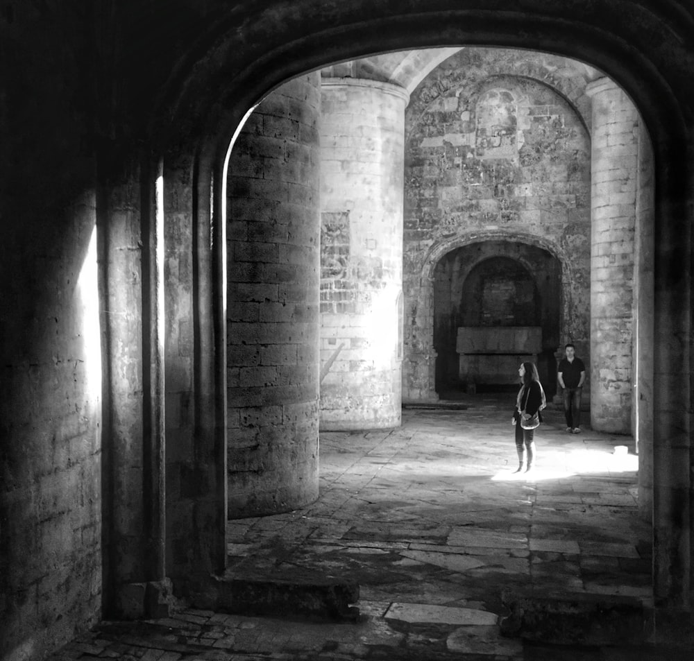 grayscale photo of man and woman inside structure