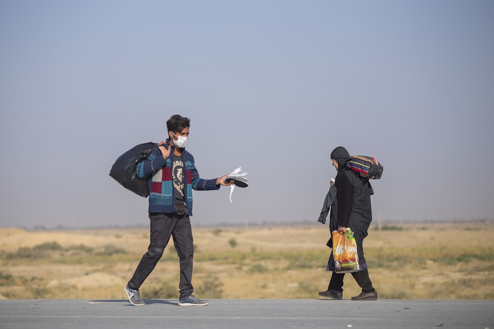 man standing near person walking on road