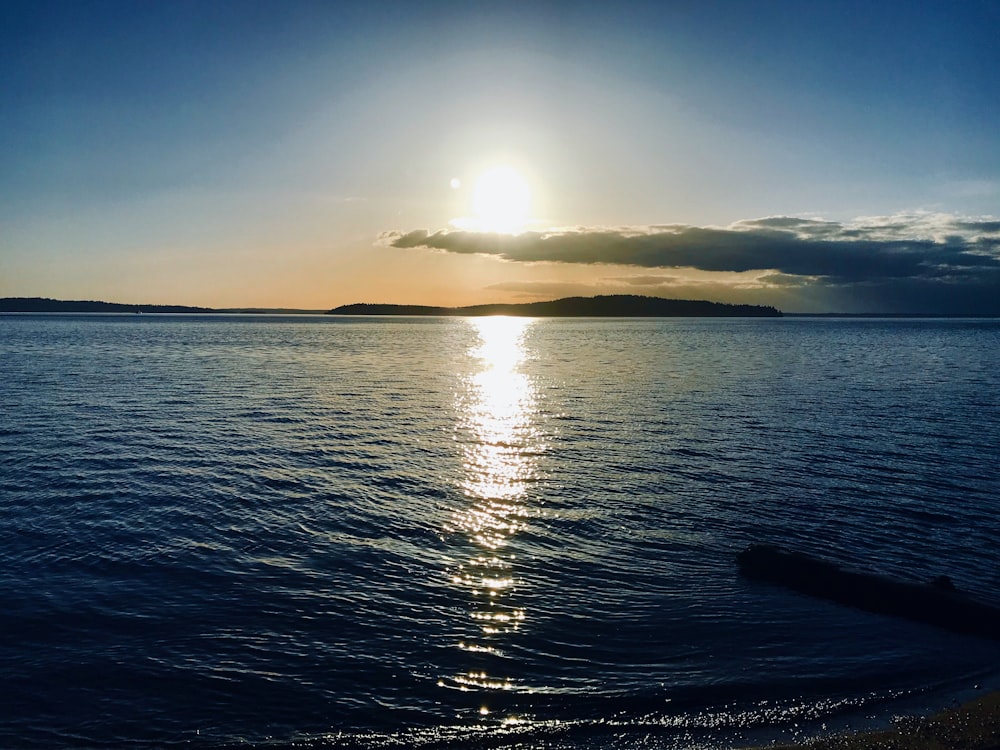 the sun is setting over the water of a lake