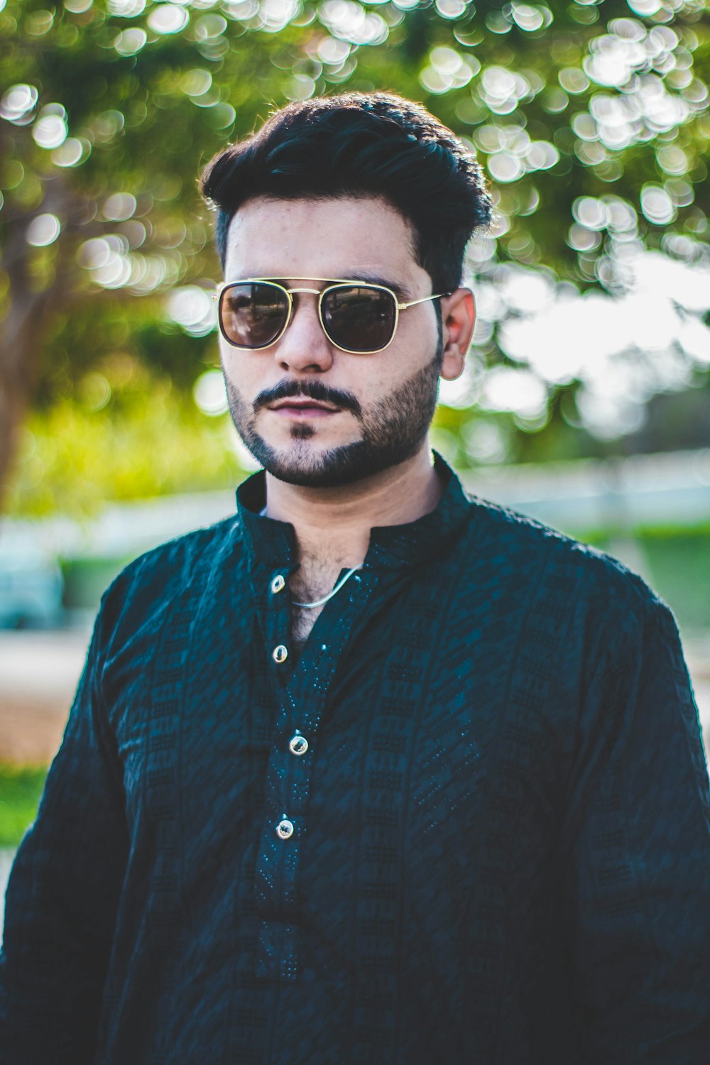 hombre con camisa de vestir azul y gafas de sol