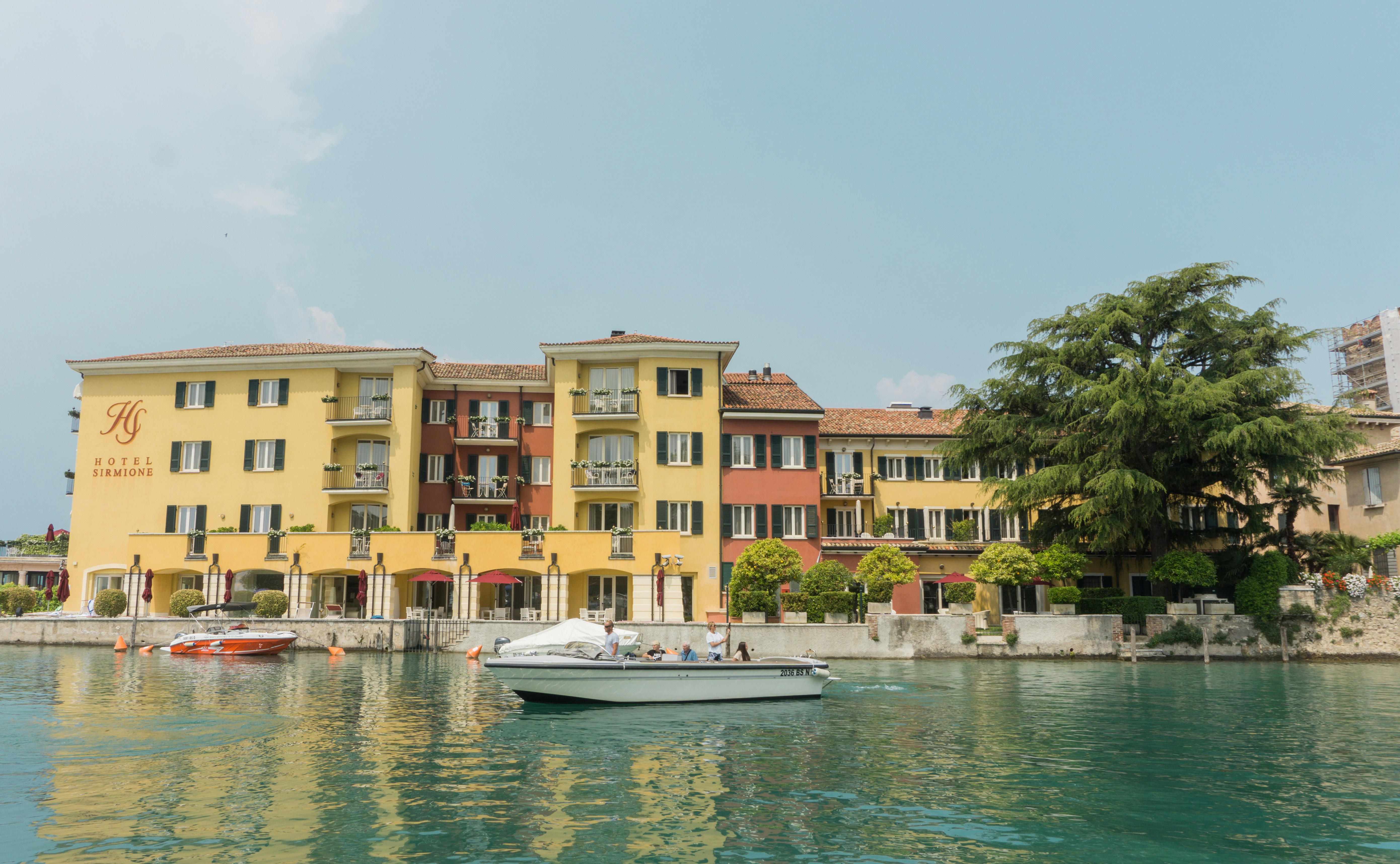 architectural photo of a yellow and brown building by a river
