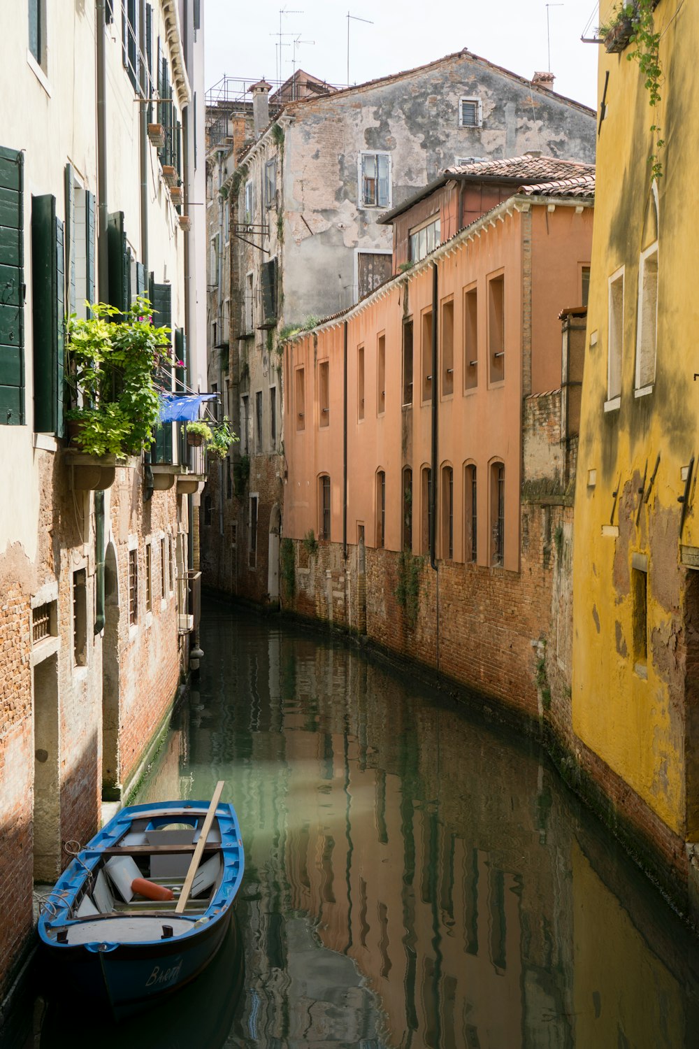 boat on a canal between concrete buildings