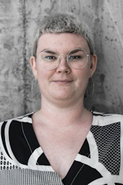 woman in black, white, and grey geometric shirt smiling