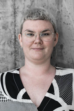 woman in black, white, and grey geometric shirt smiling