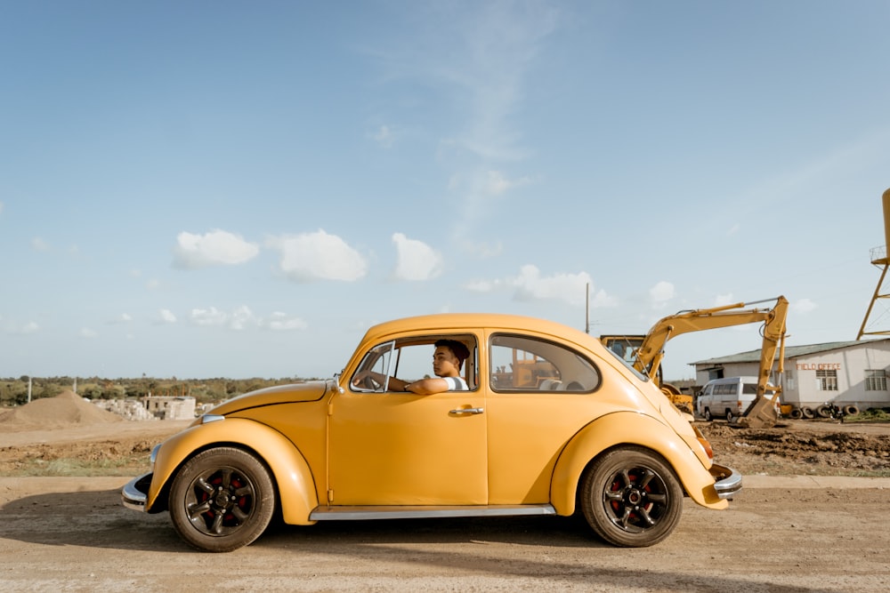 yellow Volkswagen Beetle on road