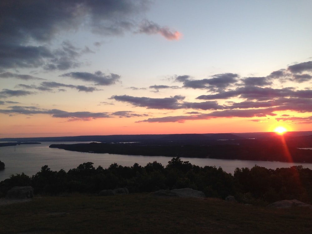 body of water across island during sunset photo