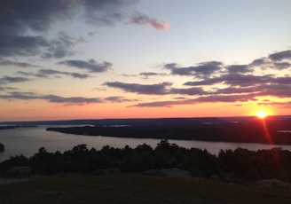 body of water across island during sunset photo