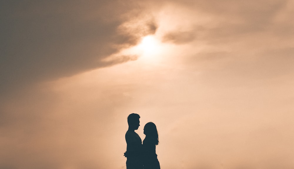 ゴールデンアワーに抱き合うカップルのシルエット写真