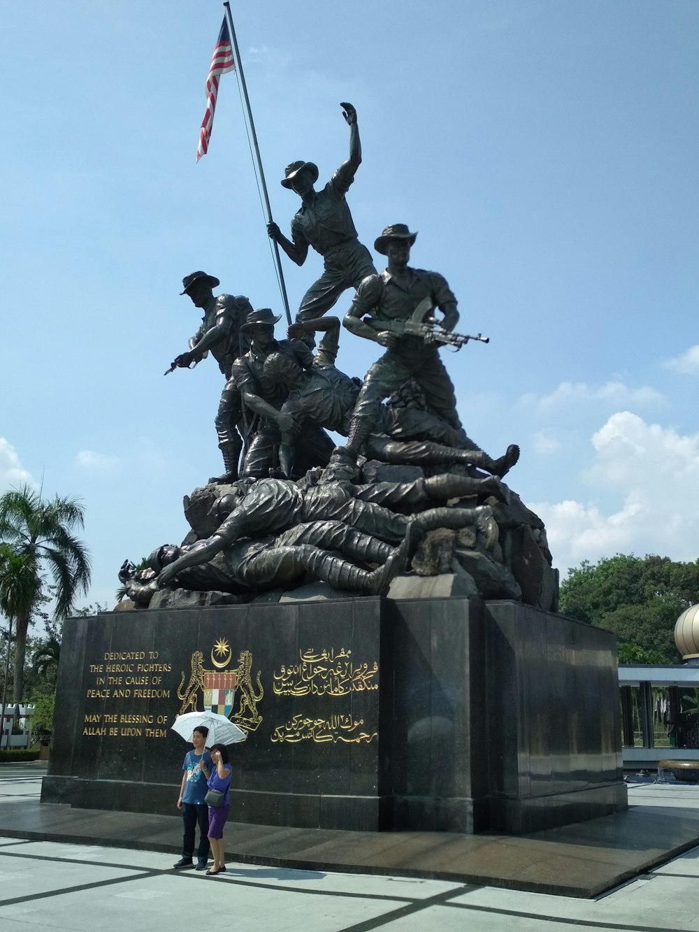 dos personas sosteniendo paraguas blanco de pie junto al Monumento Nacional de EE. UU.