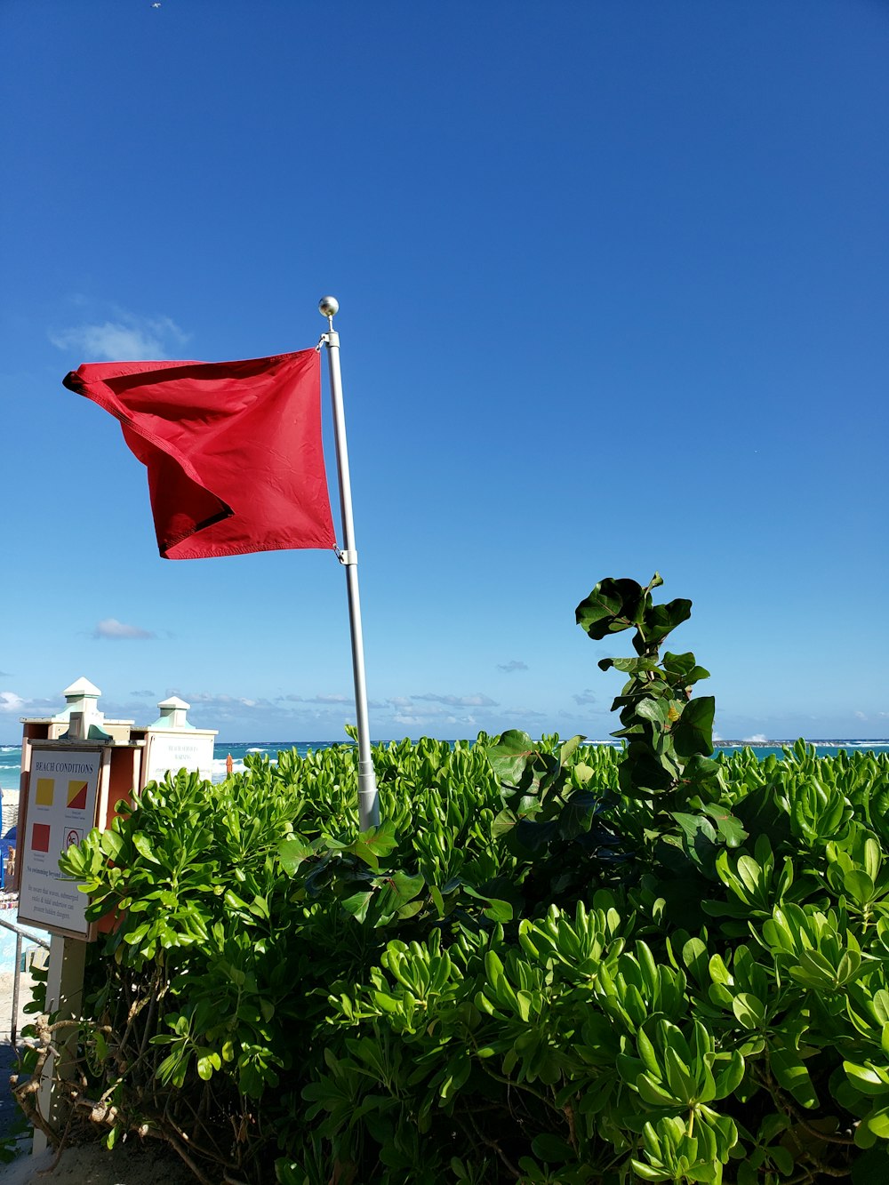 drapeau rouge sur poteau blanc