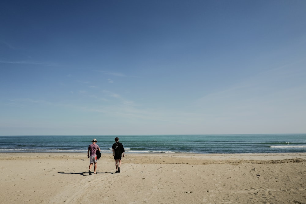 two person standing near seashore