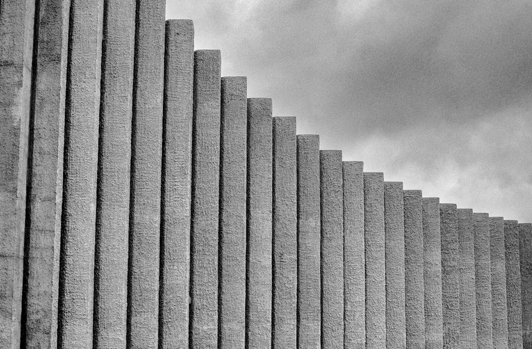 grayscale photography of concrete wall under cloudy sky