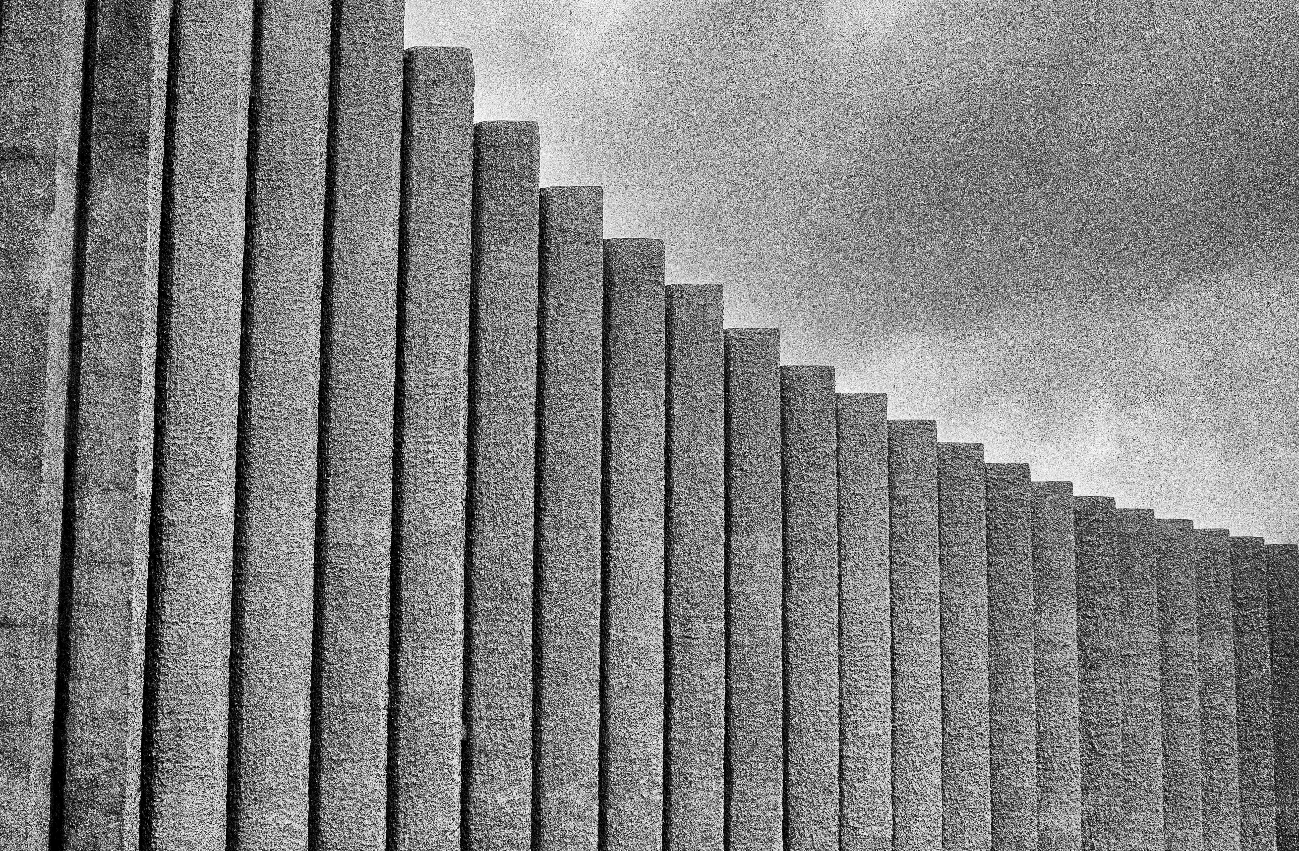 grayscale photography of concrete wall under cloudy sky