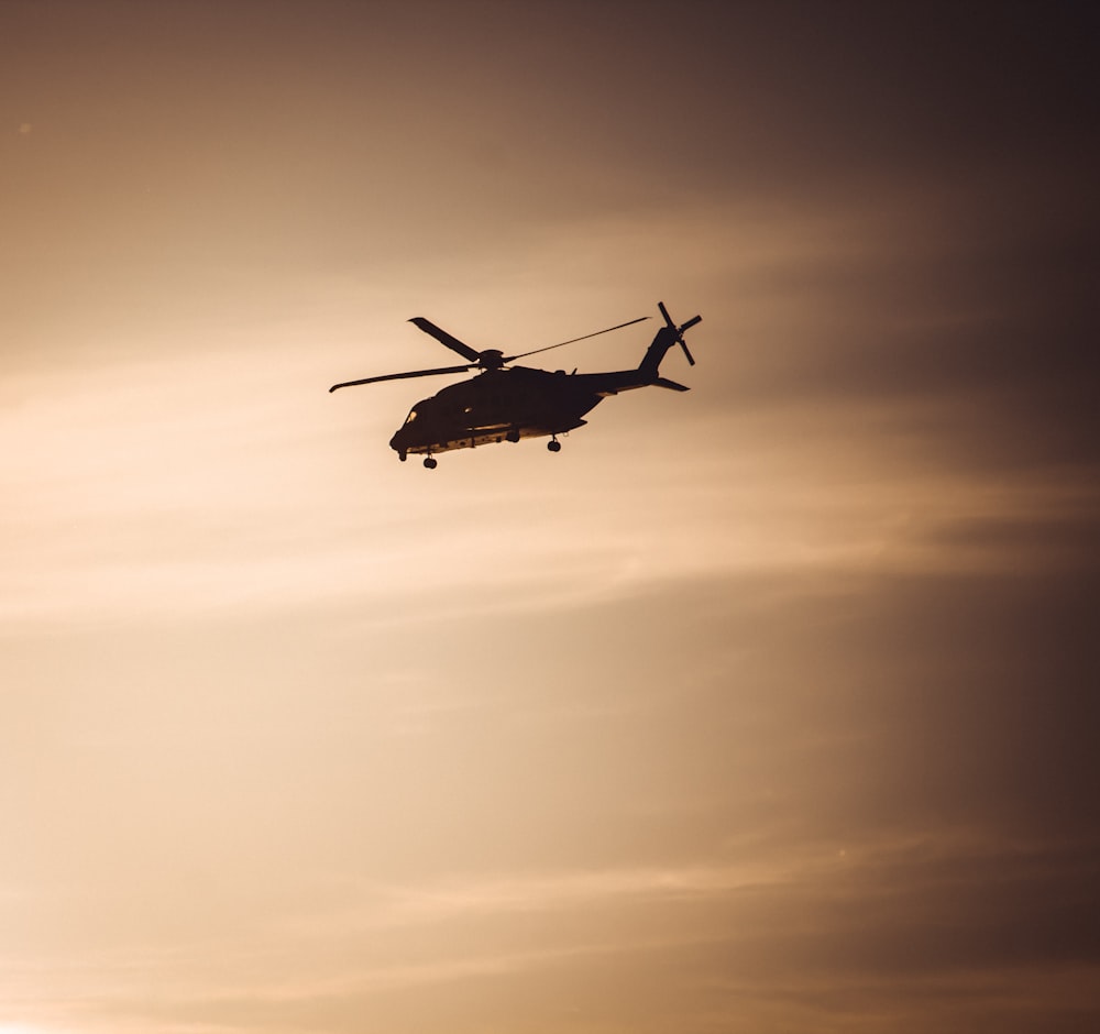 silhouette helicopter during sunset