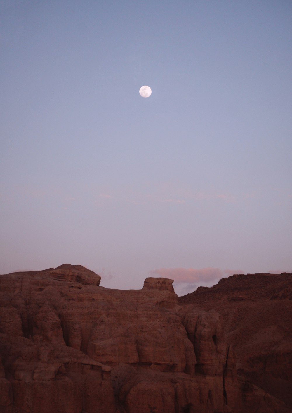 brown cliff across gray moon