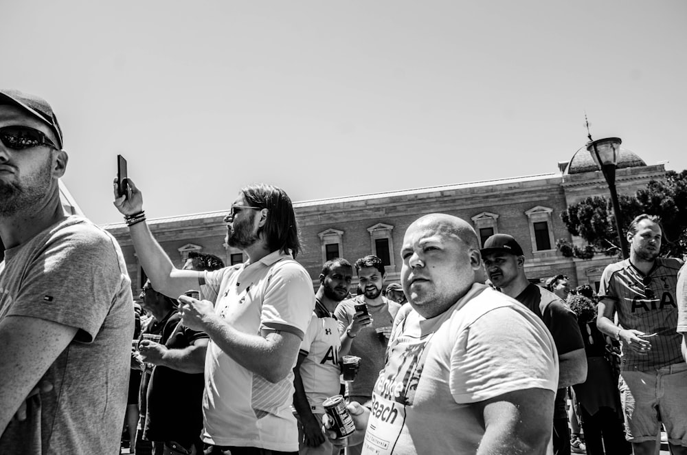 grayscale photography of group of person standing outdoors