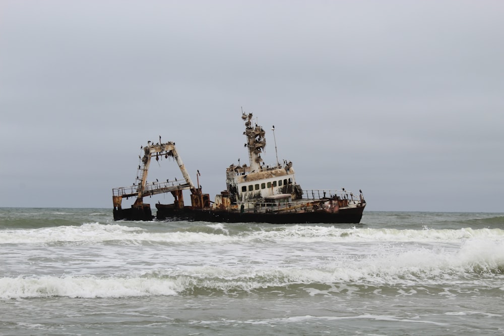 white and black fishing vessel on seashore during daytime
