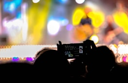 Photographer capturing a lively event with vibrant lighting and engaged audience.