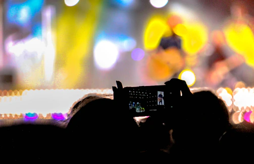A dynamic photo capturing a live music concert with vibrant lighting and crowd engagement.