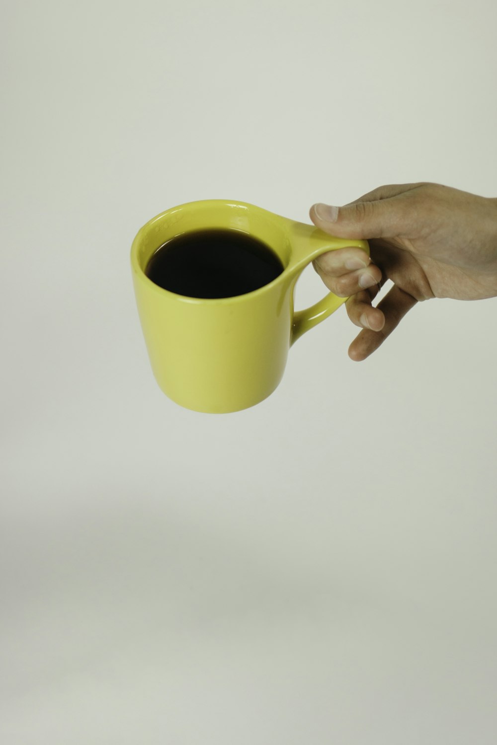 black beverage filled yellow mug