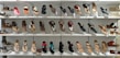 A display of various women's sandals arranged neatly on white shelves. The sandals are diverse in style, including flip-flops, strappy sandals, and wedges, showcasing a range of designs from casual to more decorative options.