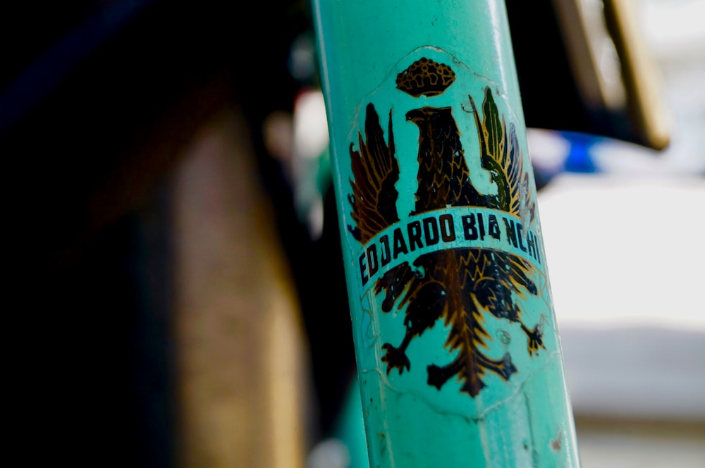 a close up of a blue bicycle with a sticker on it