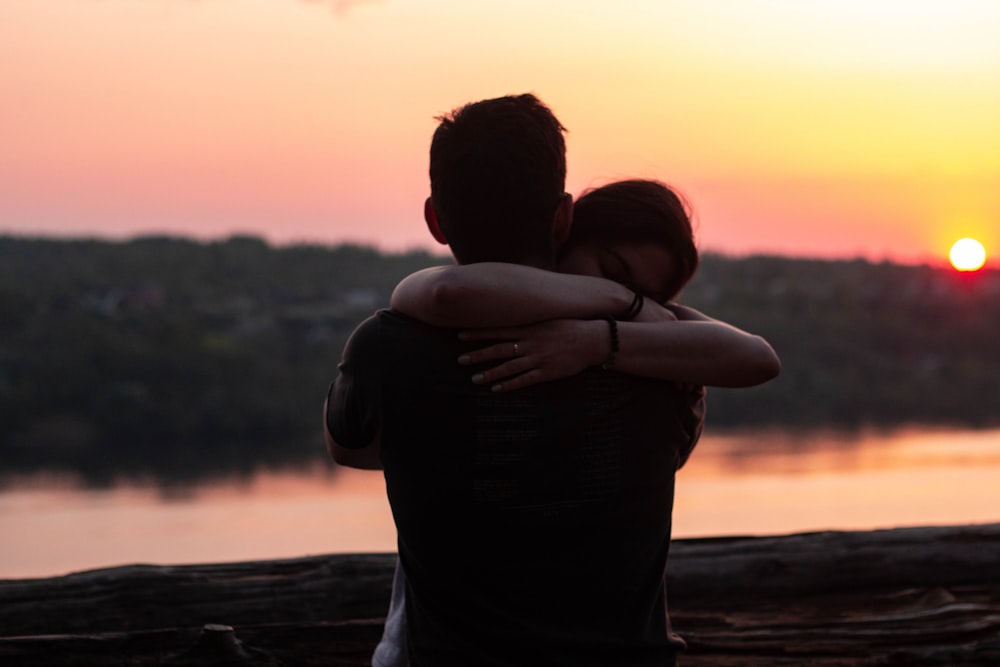 couple hugging each other during sunset