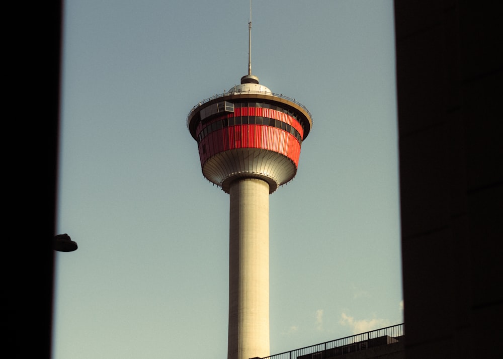 a tall tower with a red top against a blue sky