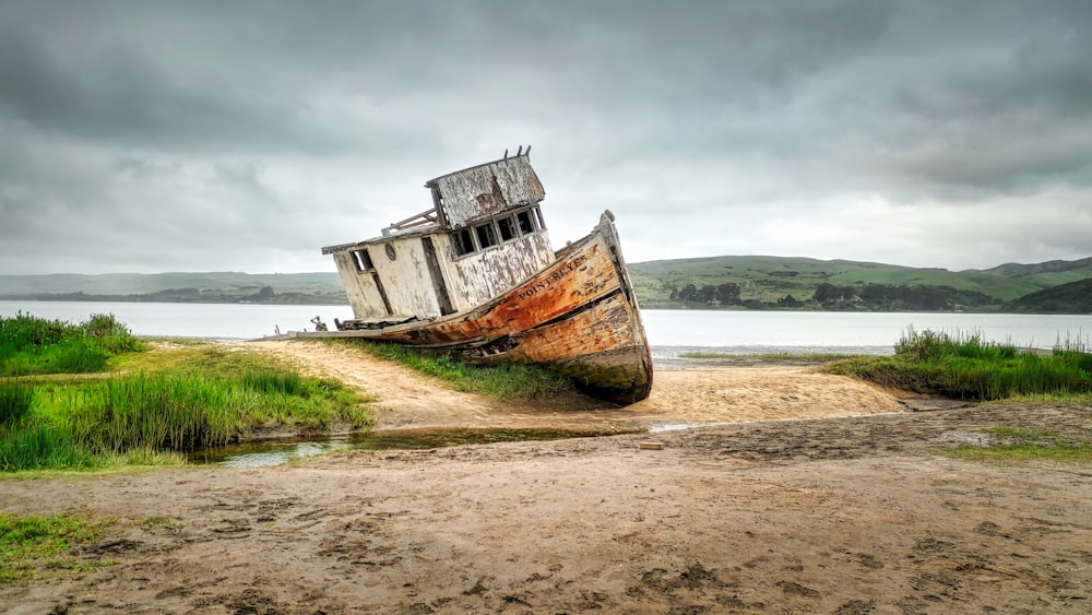 photography of brown and white boat beside body of water during daytime