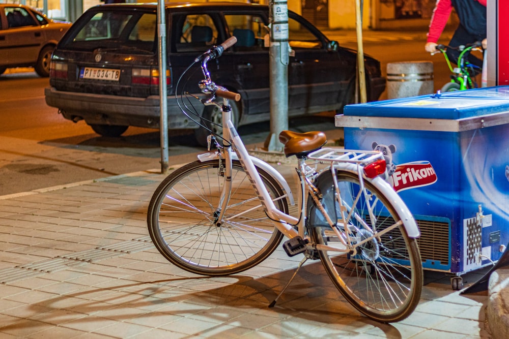 weiß-braunes Fahrrad neben Tiefkühltruhe geparkt