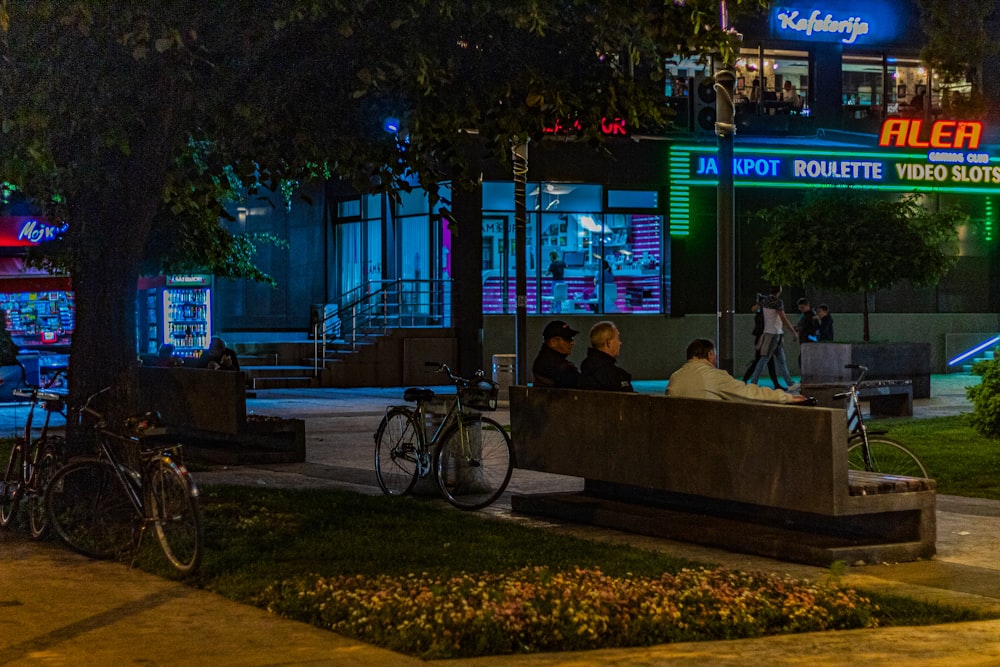 three persons sitting on bench