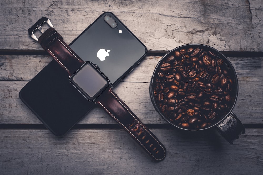 black Apple Watch on top of black iPhone 7 Plus
