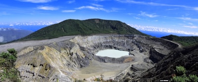 View of Segara Anak lake surrounded by volcanic peaks under a clear sky.